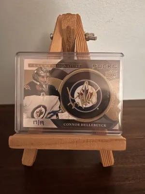 2018-19 Trilogy Connor Hellebuyck Signature Pucks Gold Auto (17/19) #SP-CH front